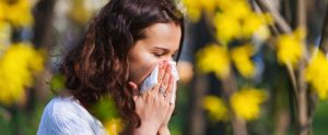 Mujer se suena debido a los síntomas de alergia